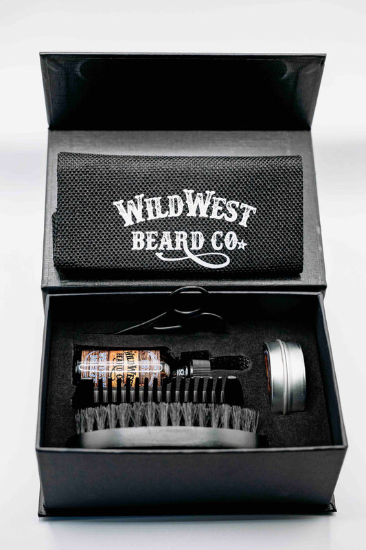 A clean picture of the Wild West Beard Co beard care gift box. With a travel bag, beard comb, beard brush, natural beard oil, natural beard balm, and snipping scissors.