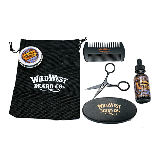 Wild West Beard Co. grooming kit with a black drawstring bag, comb, scissors, round mat, and bottle on a white background.